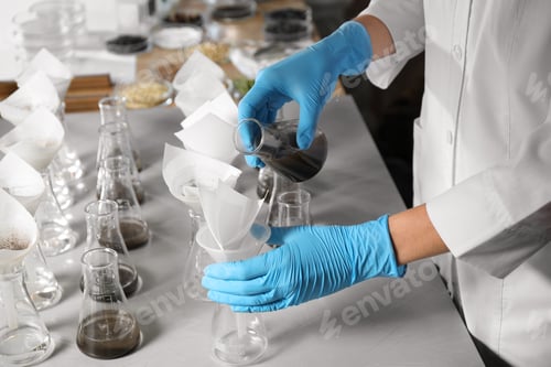Preview: Scientist filtering soil samples at table, closeup. Laboratory analysis