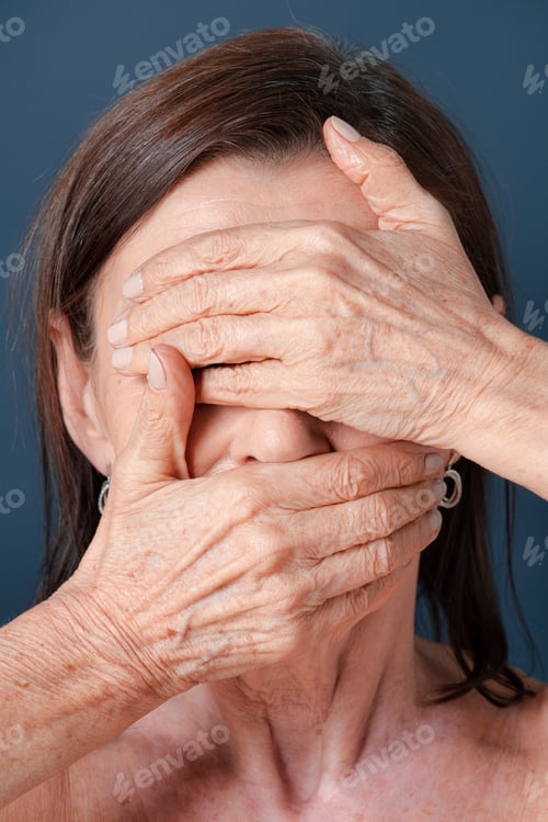Preview: Close up of a senior woman covering her face