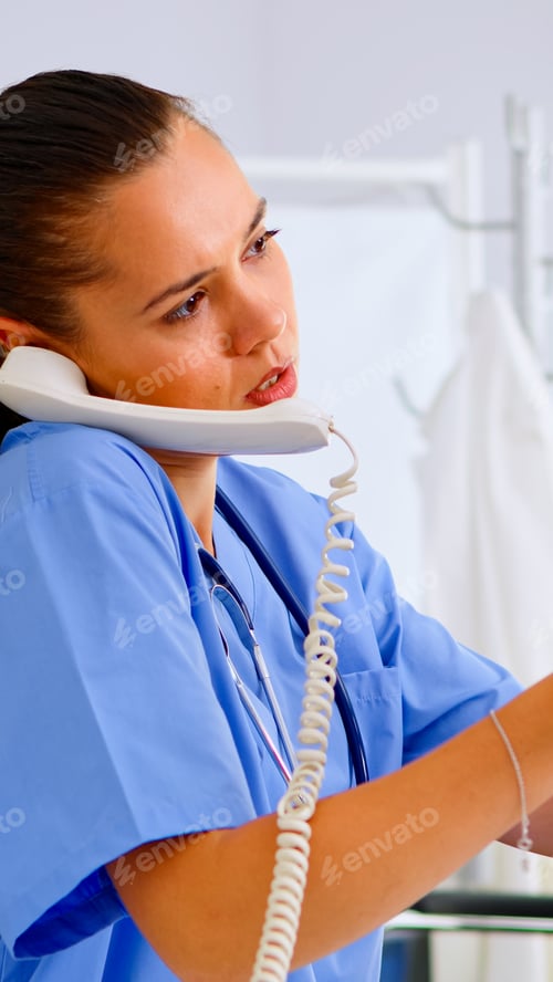 Preview: Medical nurse holding patient x-ray in hospital while talking on phone
