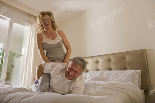 Preview: Mature couple wrestling on bed