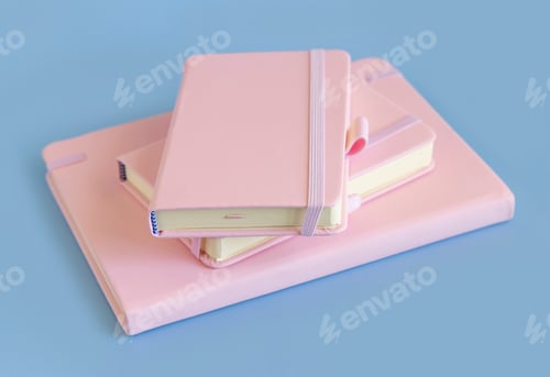 Preview: Stack of pink notebooks on light blue closeup. Textbook mockup