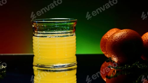 Preview: Orange alcohol cocktail in a glass on colorful wall background. Stock clip. Cold refreshing drink