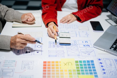 Preview: Close up view of UI developer team brainstorming on their project with laptop, smartphone
