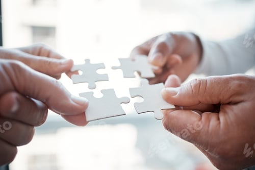 Preview: Cropped shot of four unrecognizable businesspeople building a puzzle in the office