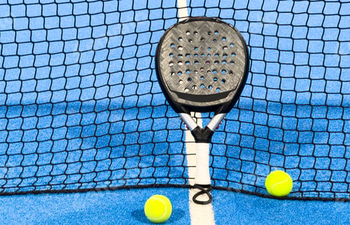 Preview: Paddle tennis: Paddel racket and ball in front of an outdoor court