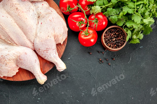 Preview: top view fresh chicken with tomatoes greens and seasonings on a dark background cooking dish salad