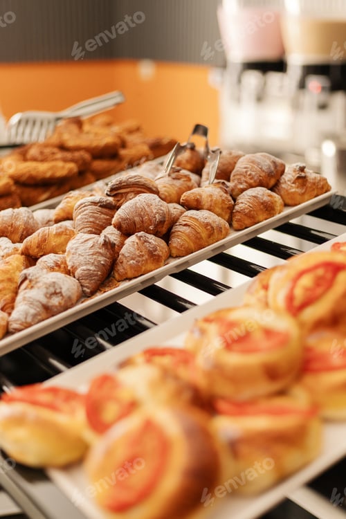 Preview: Various delicious pastries are arranged on trays, showcasing croissants, danishes, and sweet rolls
