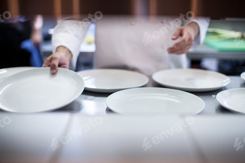 Preview: Chef laying out empty plates in kitchen