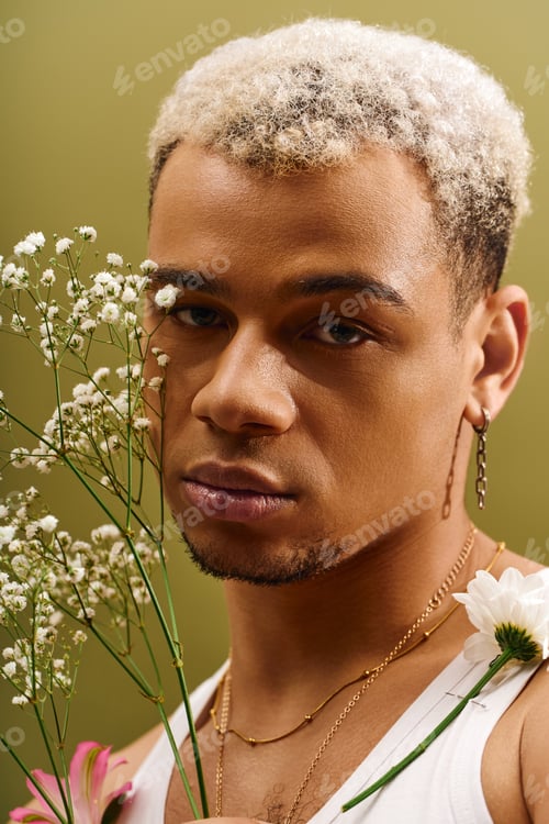 Preview: Young man with dyed hair showcases beauty in a studio setting surrounded by flowers