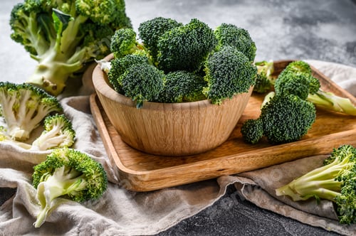 Preview: Fresh broccoli in a wooden bowl. Gray background. Top view