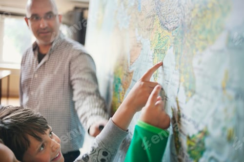 Preview: Professor looking at students pointing at map