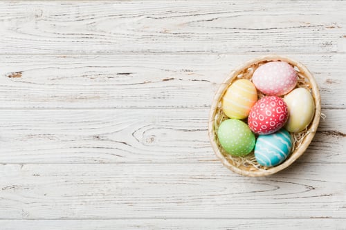 Preview: Multi colors Easter eggs in the woven basket on colored background