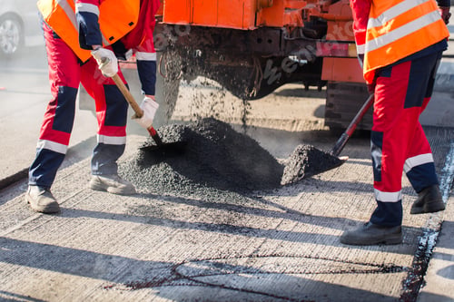 Preview: Young builder on Asphalting paver machine during Road street repairing works