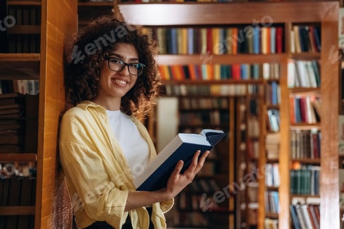Preview: Leaning on the shelf. Beautiful woman is in the library