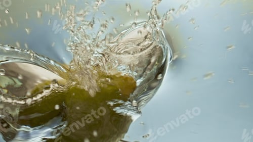 Preview: Organic lemon splashing water closeup. Beautiful surface reflecting fresh citrus