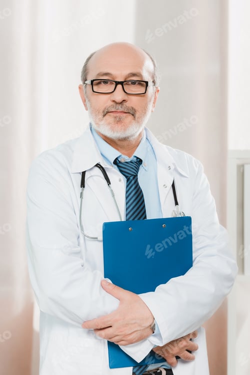 Preview: portrait of senior doctor in eyeglasses with stethoscope and notepad looking at camera