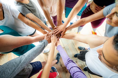 Preview: Group of diverse people stacking hands in the middle