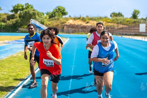 Preview: Young athletes running on blue track during competition