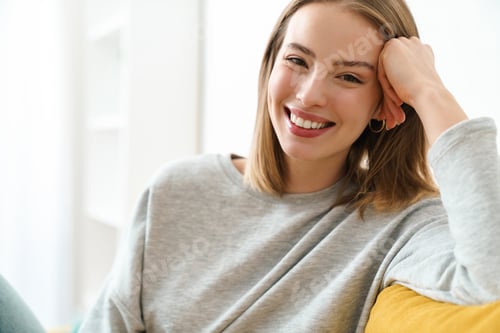 Preview: Smiling Woman Relaxing at Home on Couch