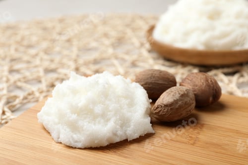 Preview: Shea butter and nuts on wooden board, closeup