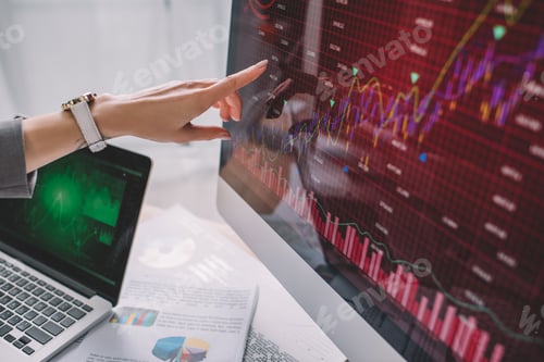 Preview: Cropped view of information security analyst pointing with finger on charts on computer monitor