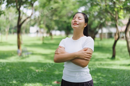 Preview: Woman feeling peaceful embracing nature in park