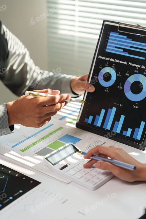 Preview: Business team analyzing financial charts discussing and planning strategy using calculator and point