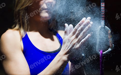 Preview: Climber woman coating her hands in powder chalk magnesium.