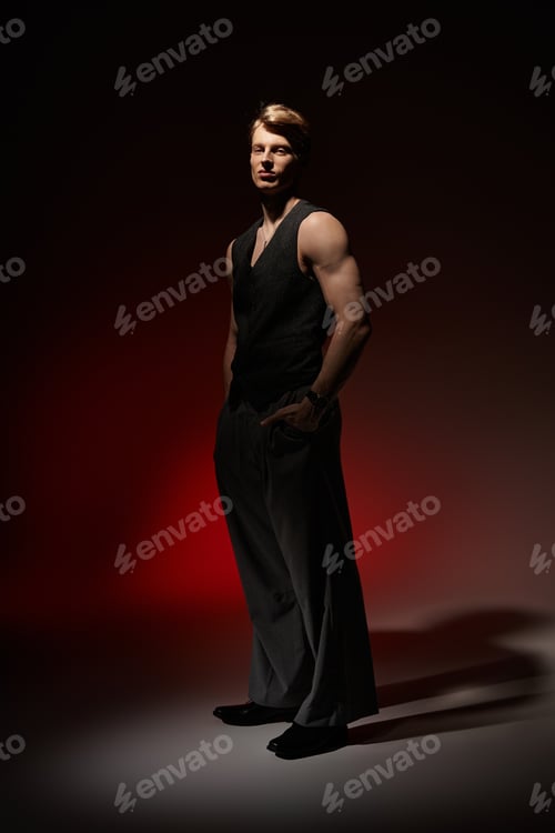 Preview: Young man embodies modern masculinity with confidence in artistic lighting