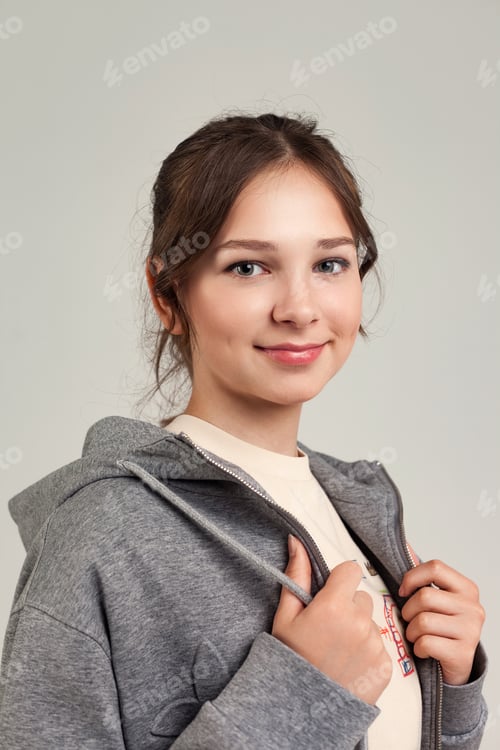 Preview: Smiling Teen in a Grey Hoodie Posing Against a Studio Backdrop