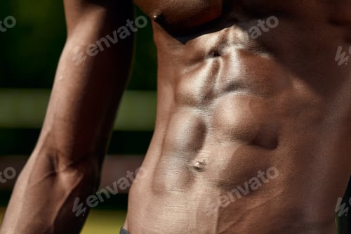 Preview: Male muscular belly, close-up, black man's abdominal relief.