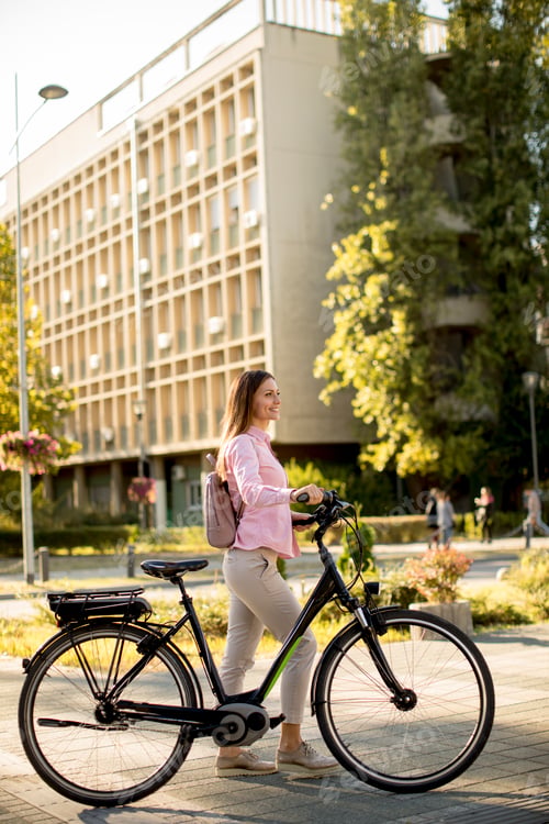 Preview: Young woman with modern city electric e-bike clean sustainable urban transportation