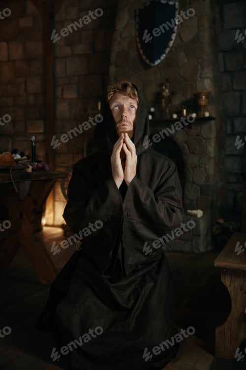 Preview: Desperate monk praying to God looking upward in monastery