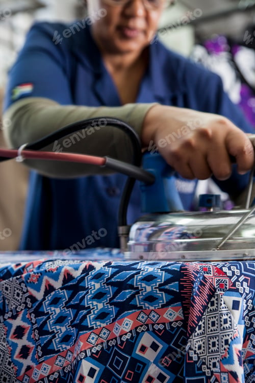 Preview: Worker ironing dress in garment factory