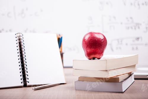 Preview: Books, notebook and pencils on table with a blurred white board