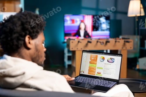 Preview: Self employed man working in personal office, checking statistical data