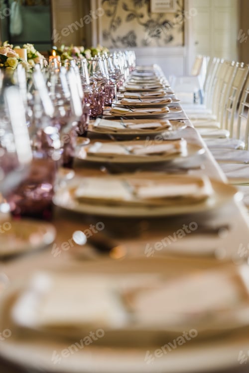 Preview: Elongated table with all the cutlery elegantly arranged and beautiful centerpieces