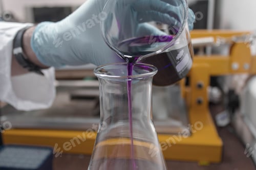 Preview: Person with blue gloves doing experiments with test tubes and purple liquid