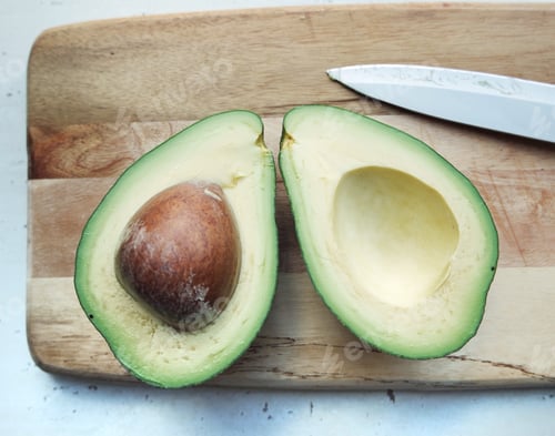 Preview: Sliced Avocado With Seed on Cutting Board