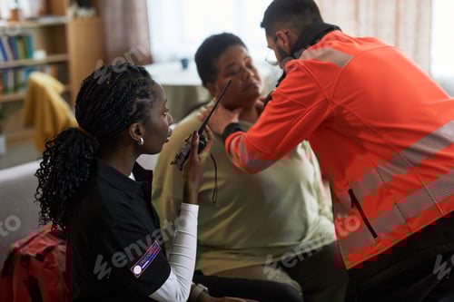 Preview: Middle Aged Black Woman Receiving Medical Assistance from Paramedics Indoors