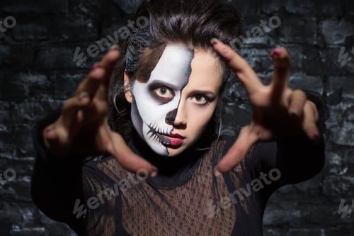 Preview: Death girl with skull makeup stretching hands toward camera.