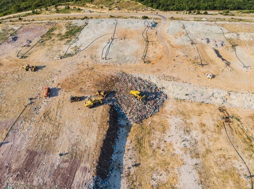 Preview: Aerial view from above of dumping site. Garbage trucks. Yellow tractor. Waste sorting. Landfill of