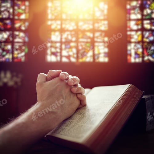 Preview: Praying hands on a Holy Bible