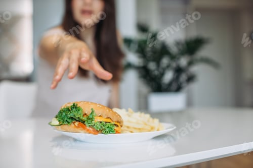 Preview: A woman's hand reaches for a big juicy burger.