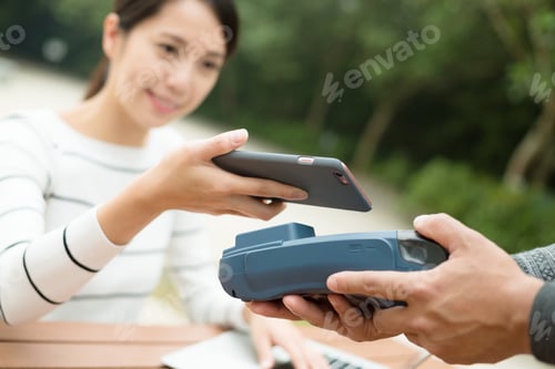 Preview: Woman pay with cellphone by NFC technology