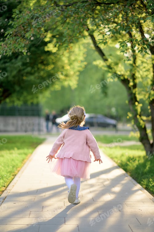Preview: A little girl 3 years old in a summer dress runs away.