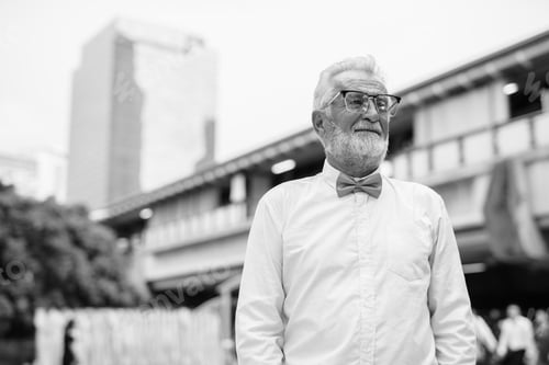 Preview: Handsome bearded senior tourist man exploring the city in black and white