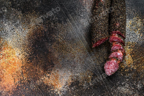 Preview: Fuet, Salami. Traditional Spanish sausage. Black background. Top view. Space for text