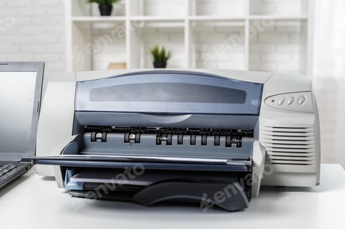 Preview: Printer and laptop on a desk in a bright workspace with white walls and plants