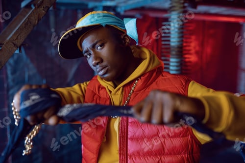 Preview: Stylish rapper in yellow hoodie posing in studio
